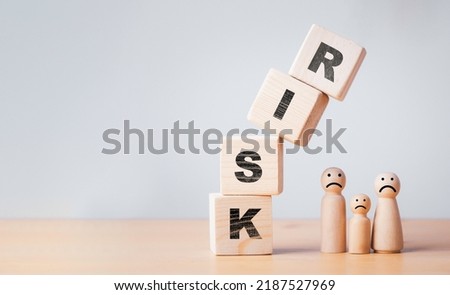 Risk wooden block cube falling to Family wooden figure for health assurance and insurance of risk assess management business analysis concept.