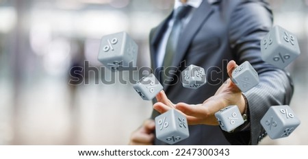Risky investment concept.Businessman throws dice with percent inscription on blurred background.