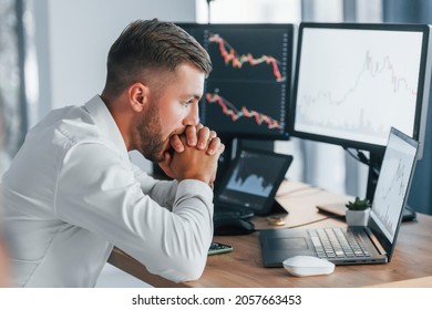 Risky Job. Young Businessman In Formal Clothes Is In Office With Multiple Screens.