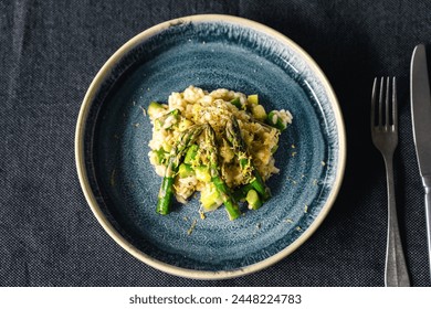 Risotto with green asparagus with lemon zest on a blue plate - Powered by Shutterstock