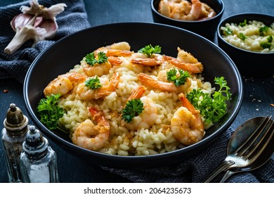 Risotto with prawns, chili and parsley on wooden table
