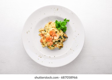 Risotto with shrimp. On a wooden background. Top view. Free space for your text.