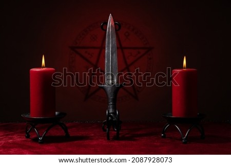 Ritual blade, pentagram symbol and candles. Black magic ritual or spell with occult and esoteric symbols. 