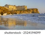 The Ritz Carlton Hotel at Half Moon Bay, California, glows in the soft light of a Pacific sunset. This luxurious landmark, set against the coastal landscape, showcases the serene beauty of the area.