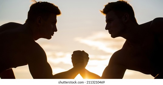 Rivalry, closeup of male arm wrestling. Men measuring forces, arms. Two men arm wrestling. Rivalry, vs, challenge, hand wrestling. Sunset, sunrise.