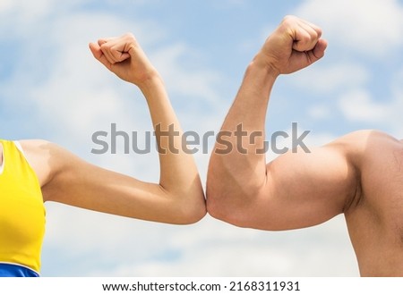 Rivalry concept. Hand, man arm fist Close-up. Rivalry, vs, challenge, strength comparison. Sporty man and woman. Muscular arm vs weak hand. Vs, fight hard. Competition, strength comparison.