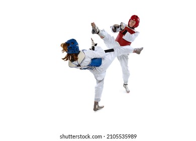 Rivals. Portrait Of Two Young Women, Taekwondo Athletes Practicing, Fighting Isolated Over White Background. Concept Of Sport, Education, Skills, Workout, Health. Sportsmen Wearing Doboks