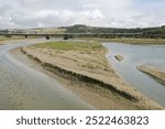 The River Adur estuary at low tide showing mudbanks. Shoreham, West Sussex, England. A27 main road flyover in background.