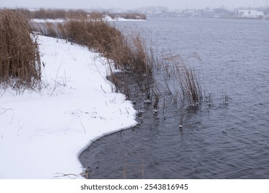 River bank is covered with snow, winter natural landscape during snowfall - Powered by Shutterstock