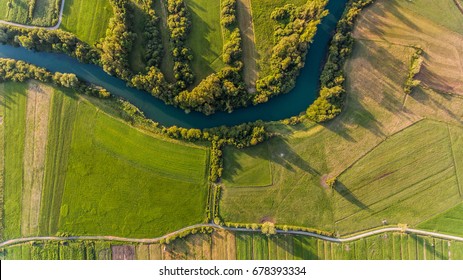 River Bend Surrounded By Fields From Bird's Eye View.