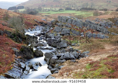 The River Claerwen in the Elan Valley, Wales flows between some rocks.
