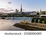 River cruise ship moored in Rouen, on Seine River, near cathedral, Pierre Corneille bridge and Lacroix island in foreground, the anchor comes from French navy ship "Jeanne d