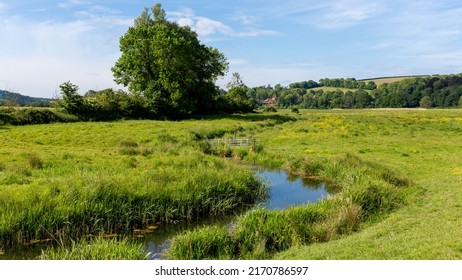 The River Cuckmere Meandering Through Picturesque Water Meadows On The South Downs Way Near The Village Of Alfriston In East Sussex