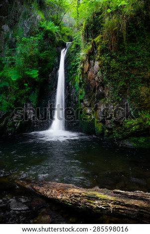 River falling over a waterfall on the mountain.