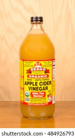 RIVER FALLS,WISCONSIN-SEPTEMBER 18,2016: A bottle of Bragg brand apple cider vinegar with a wood background.