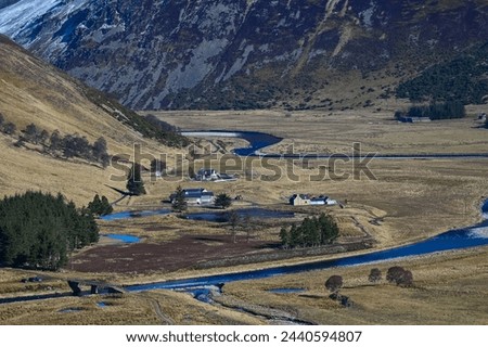 River Findhorn Kyllachy estate Strathdearn Scotland. View down valley to winding river with trees and farm buildings in winter sunlight mountain to background with snow patches. Scottish estate