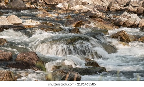 River Flowing Over Rocks Cascade On Sunny Day, Closeup Detail - Longer Exposure Photo