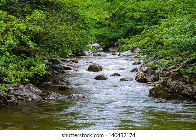 River Flowing Through The Mountain Rocks