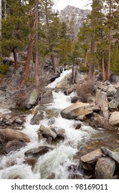 A river flows over some rocks and debris into Lake Tahoe in California.