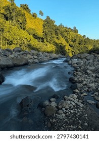 The river flows with a strong, rushing current, carrying its power through the landscape