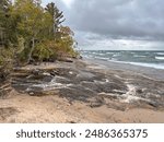 A river flows through a pine tree forest and into beautiful Lake Superior, Great Lakes, Upper Peninsula, Michigan 