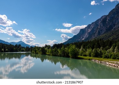 River Gail flowing through the Schuett in the natural park Dobratsch in Villach, Carinthia, Austria. Gailtaler and Villacher Alps. River gets very broad. Reflections in crystal clear water. Mountains