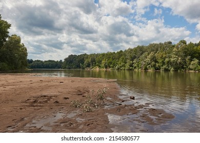 River landscape with sand bank appearing on the shore at low water levles. River Tisza, Hungary - Shutterstock ID 2154580577