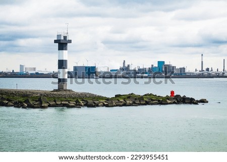 A river lighthouse in the middle of a water channel near the port of Rotterdam.