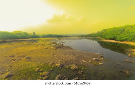 River Was Low (dry Spell), Dense Thorny Shrubby Thickets (shrubby Acacia, Catechu) On Banks, And Arid Yellow Hills (soil Drought) Around. Approaching Dust Storm (dust Devil). Karnataka, India