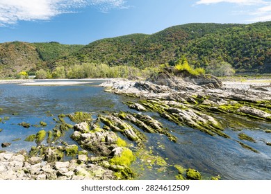 River with low water level, upper middle rhine valley near Kaub, Germany, dry riverbed due to extreme drought in Europe, impact freight transport and hinder shipping