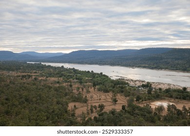 River with mountain reflection under cloudy sky