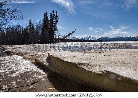 River with mountains in the background on a spring day during breakup between Tok and Delta Junction, Alaska. 