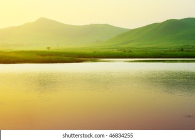 River and mountains with green grass under sunset light - Powered by Shutterstock