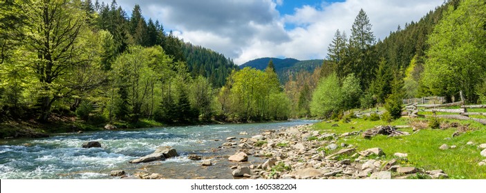 river in mountains. wonderful springtime scenery of carpathian countryside. blue green water among forest and rocky shore. wooden fence on the river bank. sunny day with clouds on the sky - Shutterstock ID 1605382204
