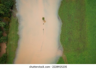 River over banks deluging fields area after heavy rain, water coming close to the houses, aerial top down shot. - Shutterstock ID 2228925235