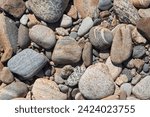 River pebbles with different textures close-up. Stone background.