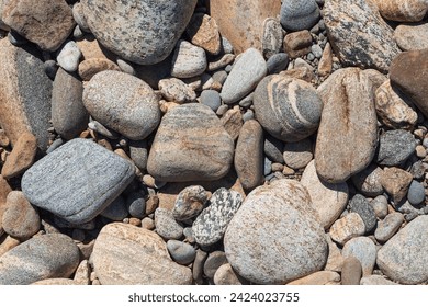 River pebbles with different textures close-up. Stone background.