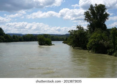 River Rhine on the border between Germany and Switzerland out of banks. High water is caused by heavy rains in  July 2021. The river banks and the vegetation are flooded with dirty muddy water. 