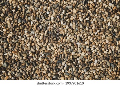 River Rock Wall Texture In Sidewalk. Close Up Crushed Rock Background Texture