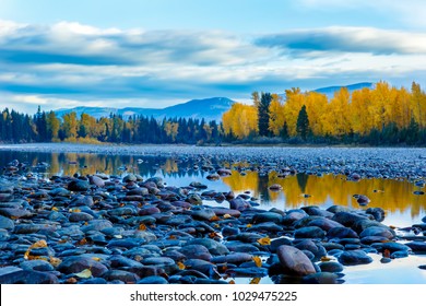 River rocks and color reflection on Flathead River, Montana in autumn with colorful fall trees
