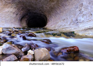 River Running Through a Dark Limestone Cave. 
Cave Stream, Castle Hill Basin, New Zealand