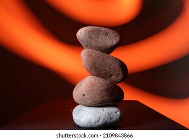 River Stone Stacked On Each Other With Orange Light Trail Background