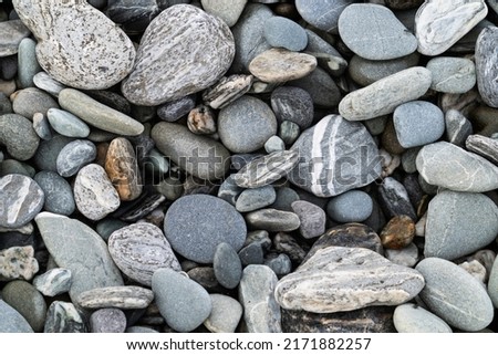 River stones in typical random pattern and type in New Zealand.