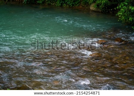 River stream blue color water flowing on stones. nature Reflections background.
