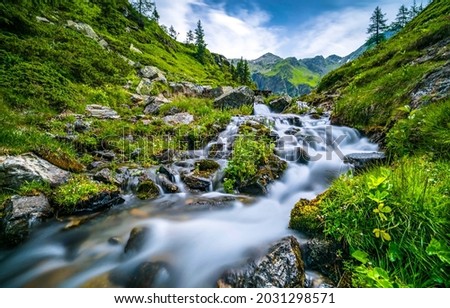 River stream on mountain hill. River waterfall flowing on nature moss