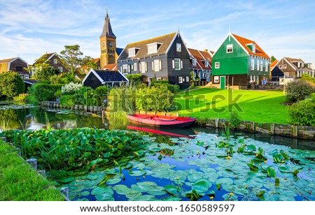 River in summer village. Housing on hill, rural meadow riverside view