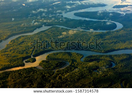 River sunrise in tropic Costa Rica, Corcovado NP. Lakes and rivers, view from airplane. Green grass in Central America. Trees with water in rainy season. Photo from air. Nature landscape near the sea.