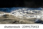 The river swollen after heavy rainfall and floodwater crashing through valley. The water flows fast from the high valley to the plain. General contest of a river in flood