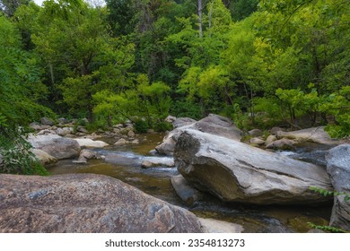 River walk along the French Broad River which locals referr to as the Rocky Broad River, sits behind shops and eateries in downtown Chimney Rock Villiage in North Carolina. - Powered by Shutterstock