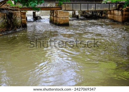 river with water flowing fast under the bridge.